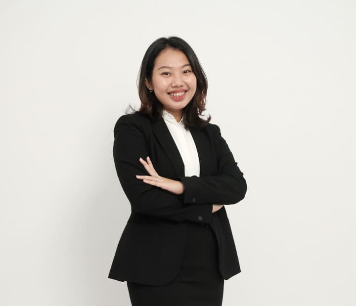 Gaby Joyce wearing a black suit and standing with her arms crossed